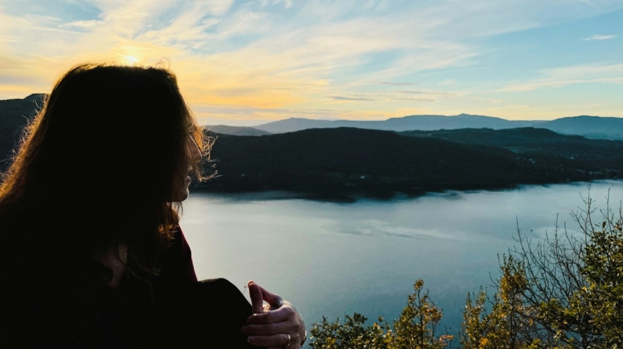 Woman looking over a river at daybreak